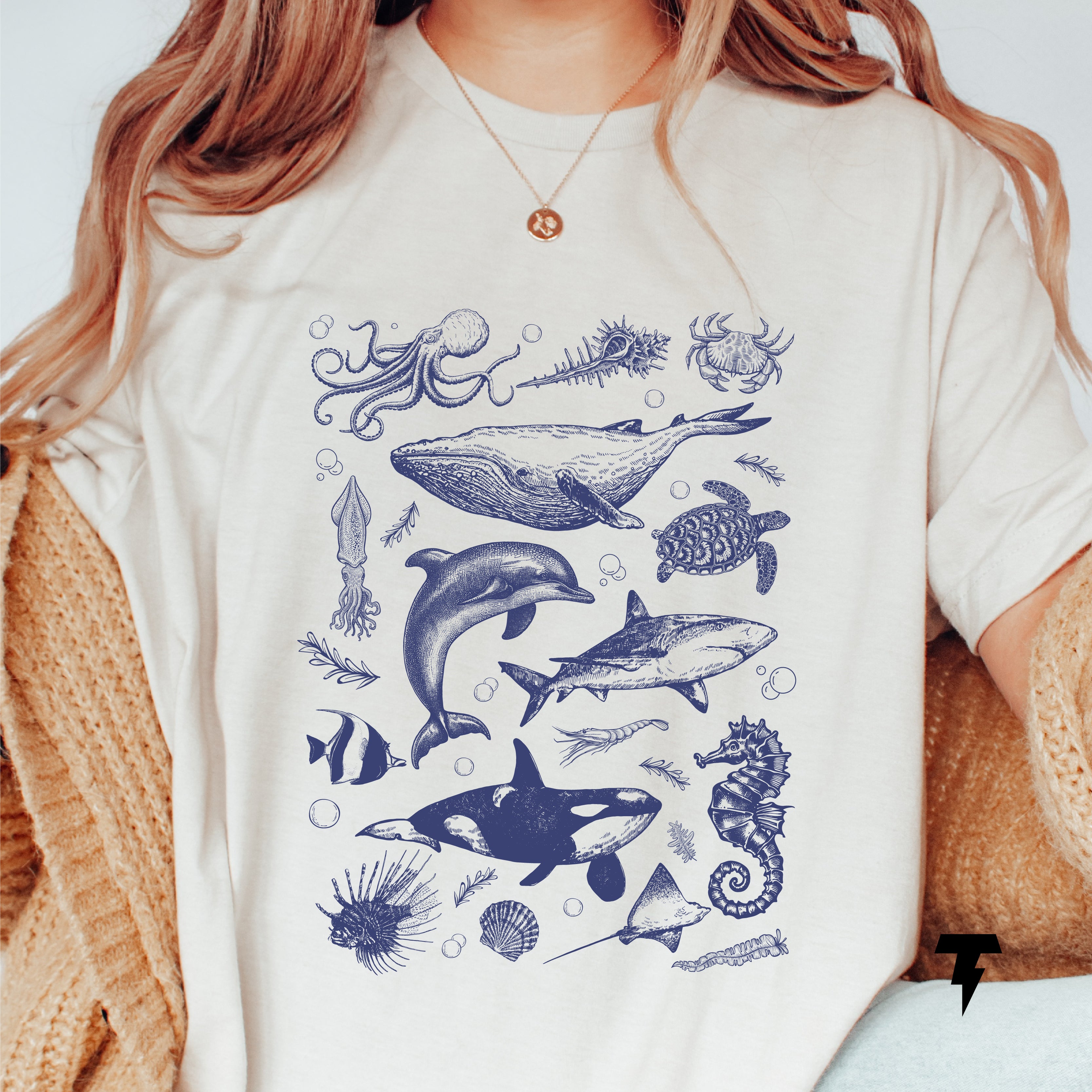 Person wearing Ocean Life Shirt with vintage illustrations of orca, whale, dolphin, shark, and sea animals; casual ocean wildlife tee.