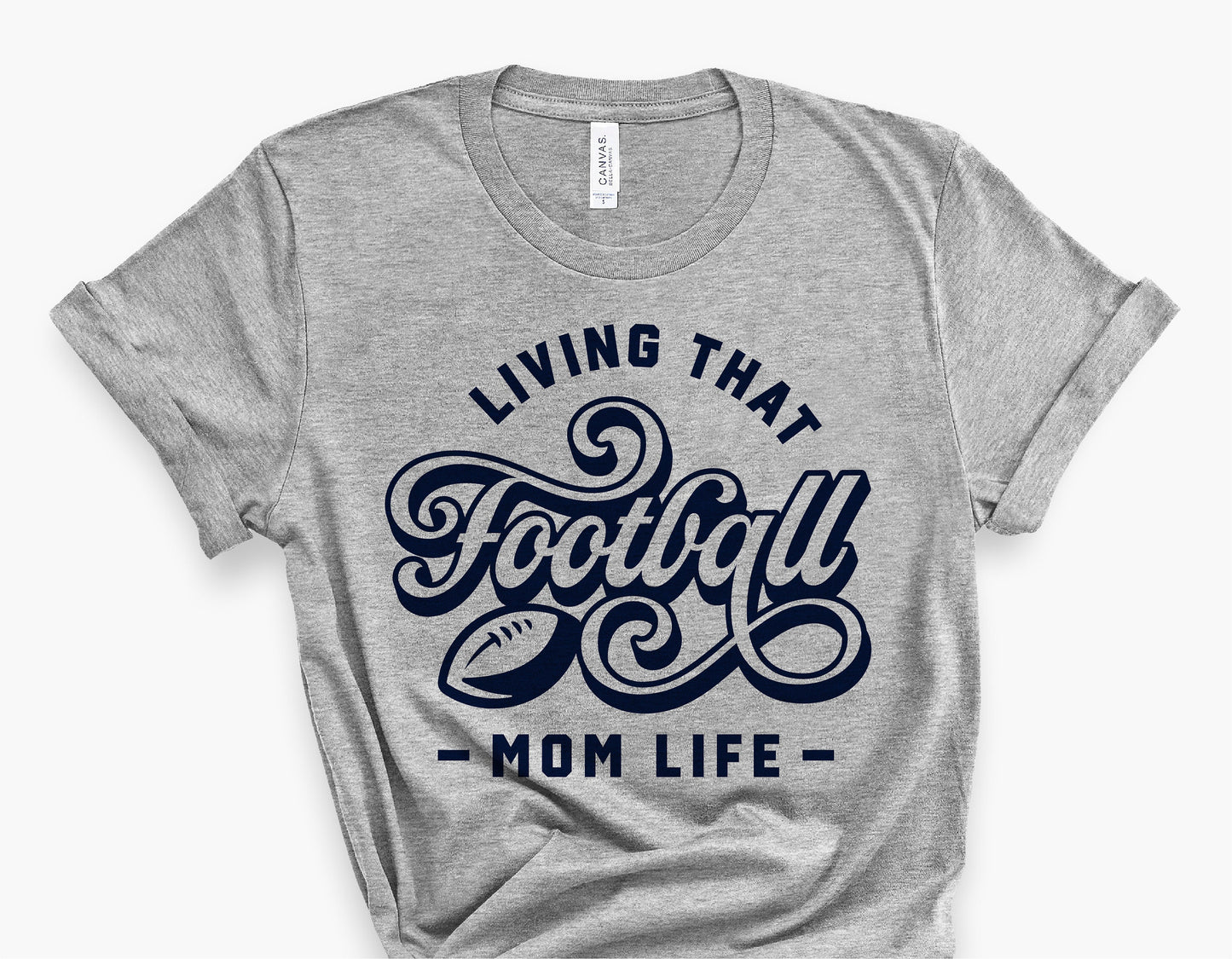 Gray t-shirt with 'Living That Football Mom Life' design in navy, ideal for football fan moms. Perfect for game days and sports events.