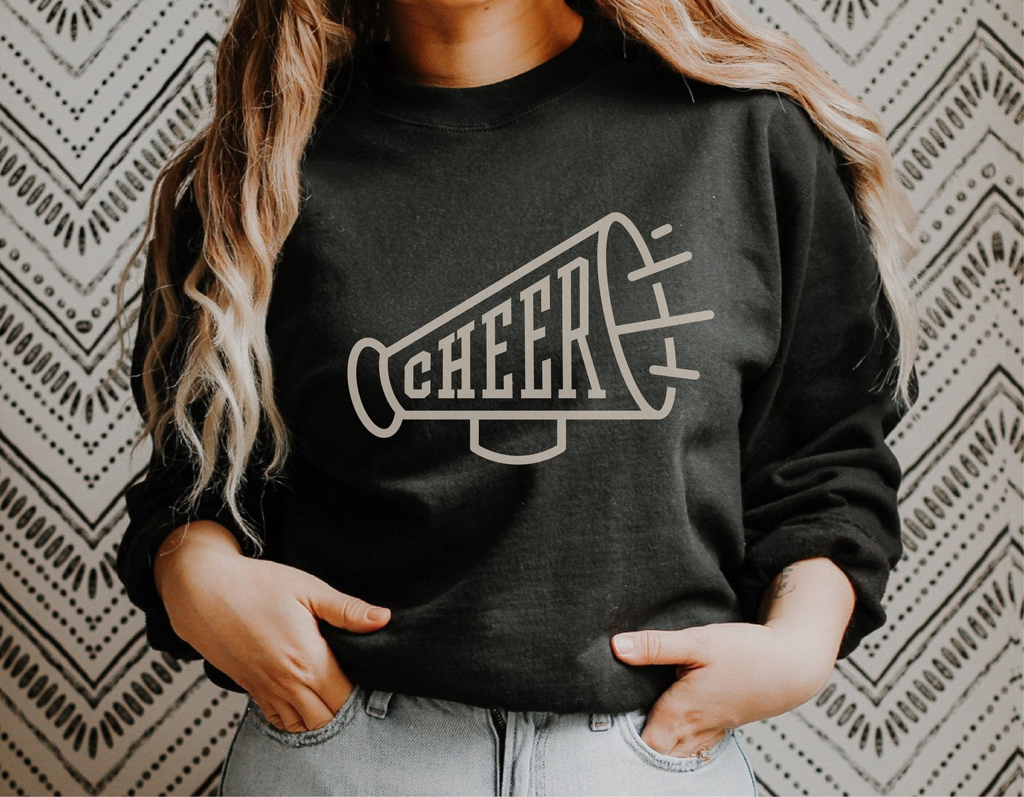 Woman wearing black sweatshirt with megaphone cheerleader SVG design, ideal for Cricut projects and cheerleading merchandise.