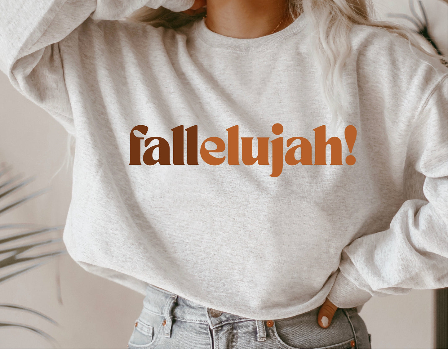 Woman wearing a light gray sweatshirt with 'fallelujah' text, perfect for autumn fashion and Cricut crafts.