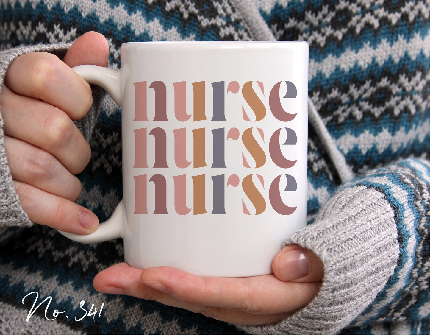 Person holding a white mug with multi-colored 'nurse' text design, wearing a gray knit sweater with black and white patterns.