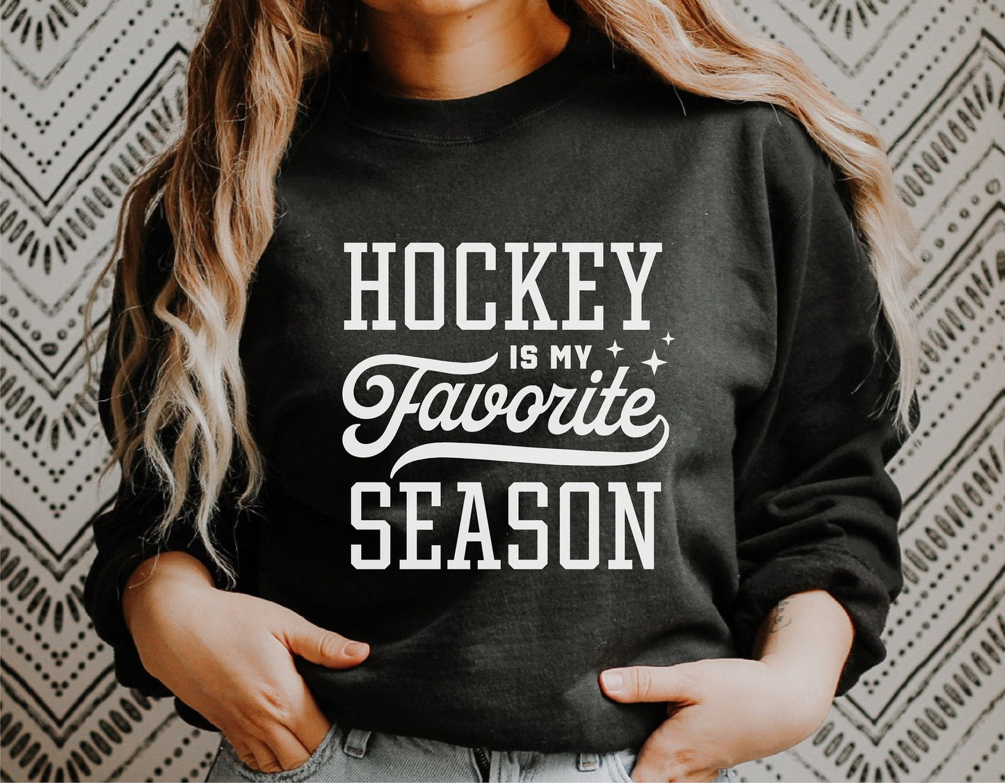 Black sweatshirt with 'Hockey Is My Favorite Season' printed, worn by person against patterned background, SVG design file display.