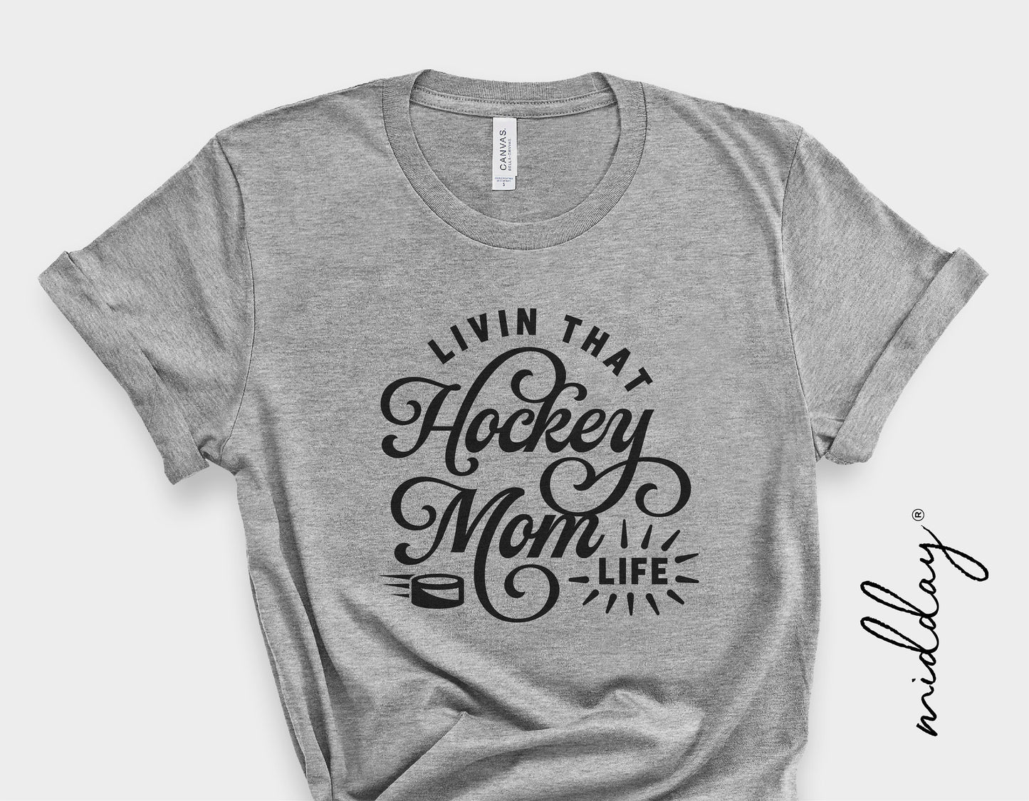 Gray T-shirt featuring 'Living That Hockey Mom Life' design in black, perfect for hockey moms, available as a digital SVG file for Cricut and Silhouette.