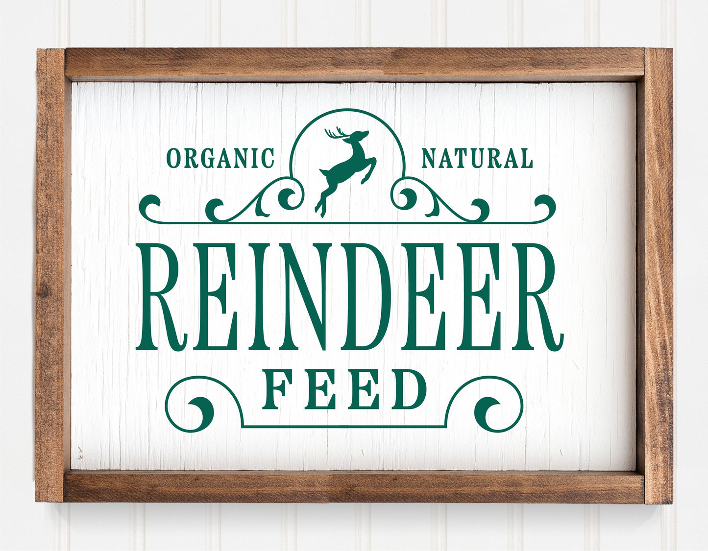 Rustic "Reindeer Feed" Christmas sign ornament with green lettering and wooden frame for holiday decor.