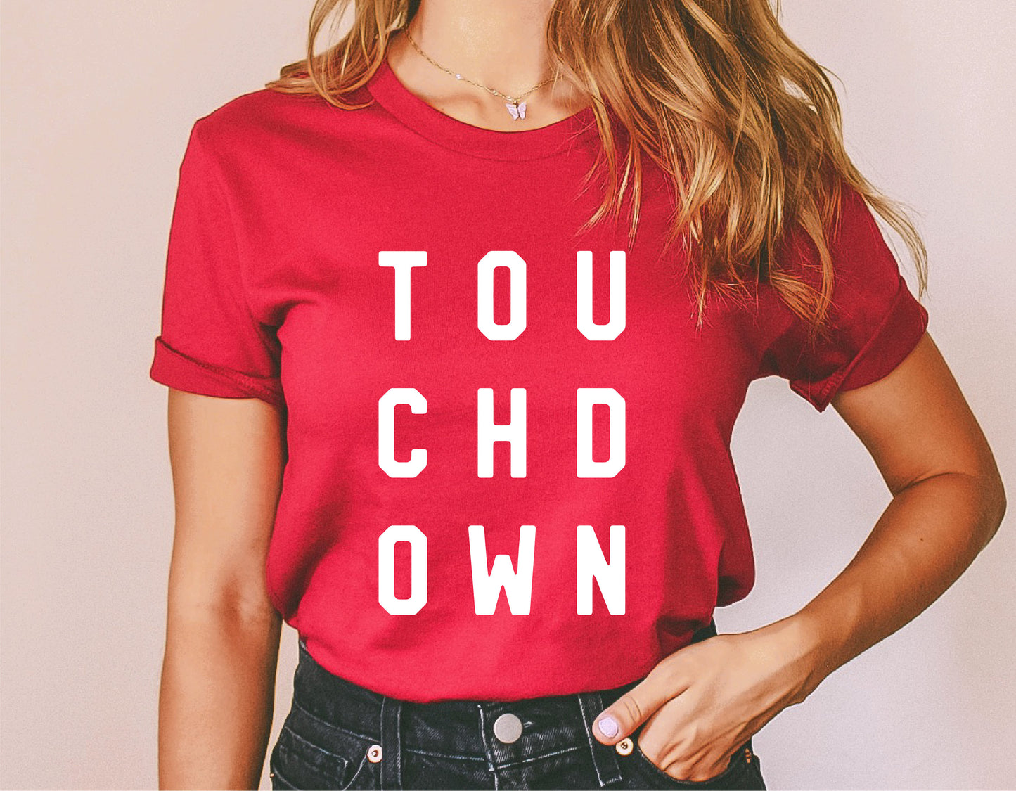 Woman wearing a red t-shirt with bold white 'TOUCHDOWN' text, ideal for football-themed SVG designs and Cricut projects.