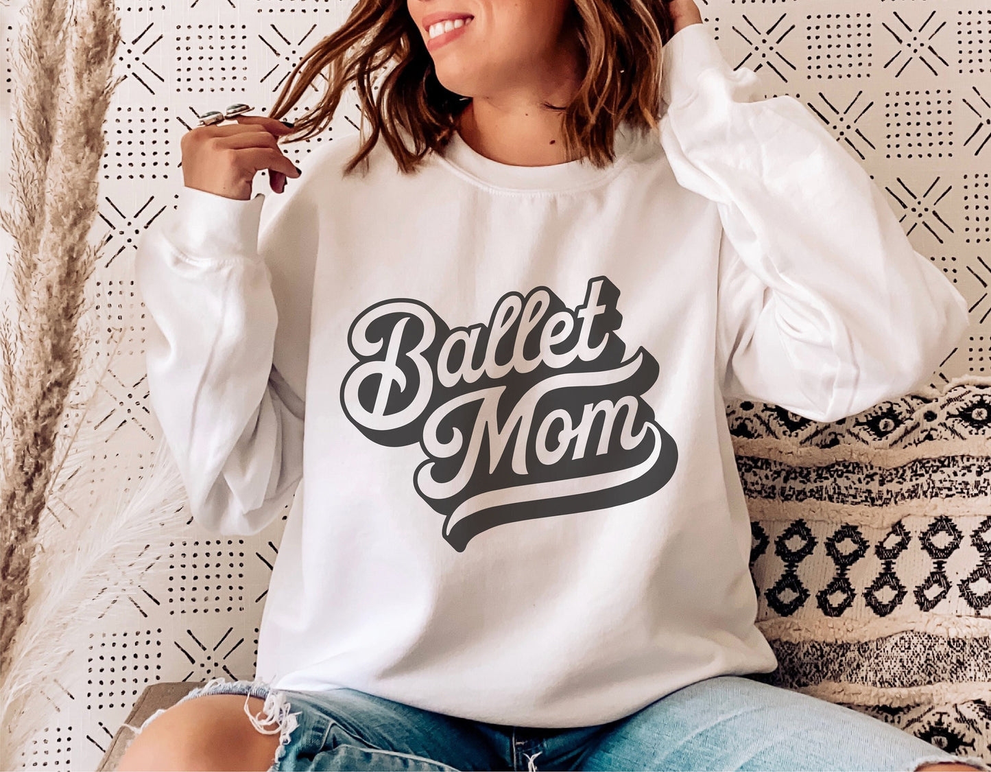 Woman wearing white sweatshirt with 'Ballet Mom' design, perfect for ballet enthusiasts. Ideal for Cricut and Silhouette projects.