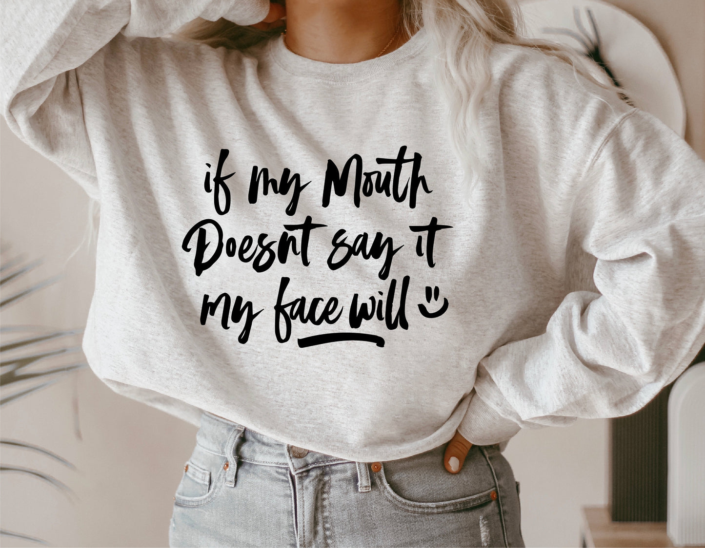Person wearing a sweatshirt with humorous text: 'If My Mouth Doesn't Say It, My Face Will'