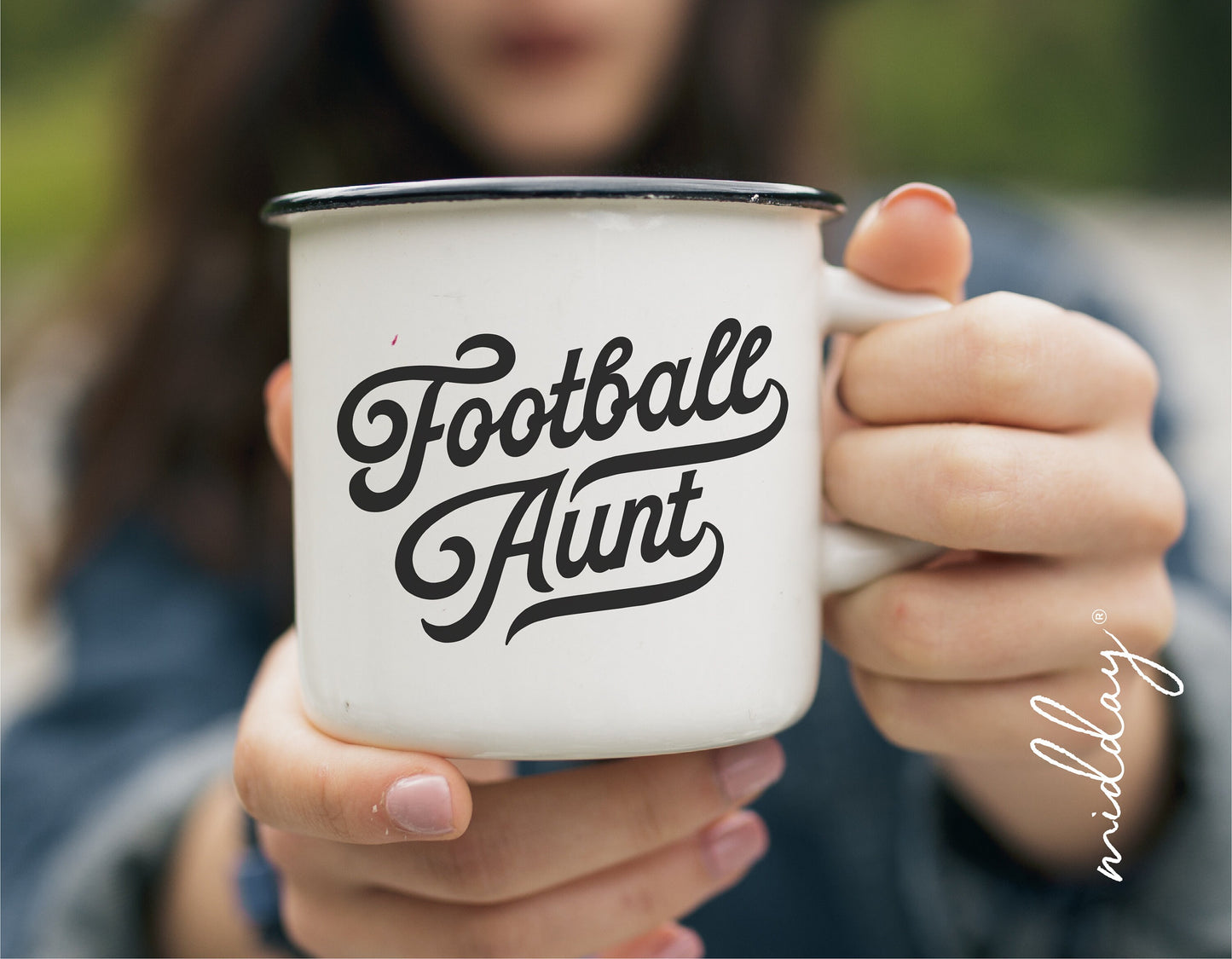 Person holding a white mug with 'Football Aunt' printed on it, showcasing a lifestyle associated with being a football fan.