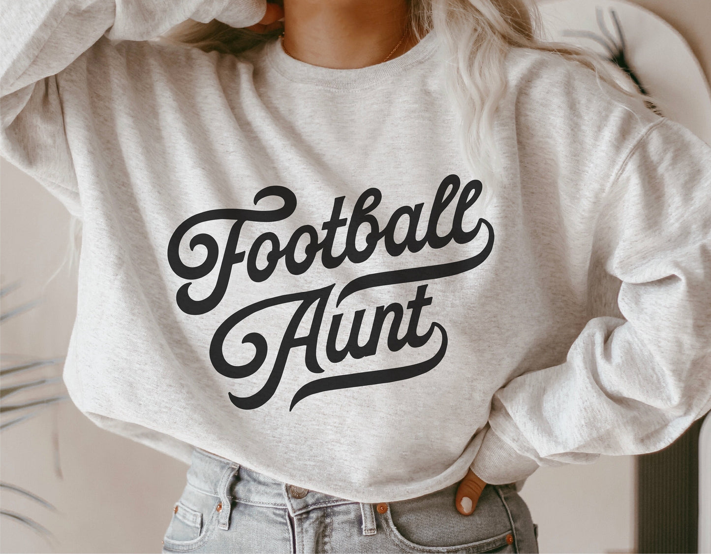 Woman wearing vintage "Football Aunt" sweatshirt, ideal for sports fans and family gatherings, featuring stylish script lettering.