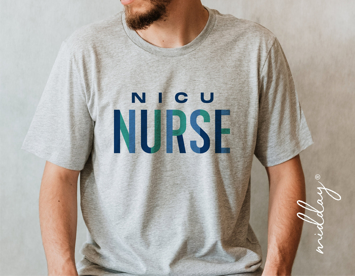 Gray t-shirt with 'NICU Nurse' text in blue and green, worn by a man sitting down.
