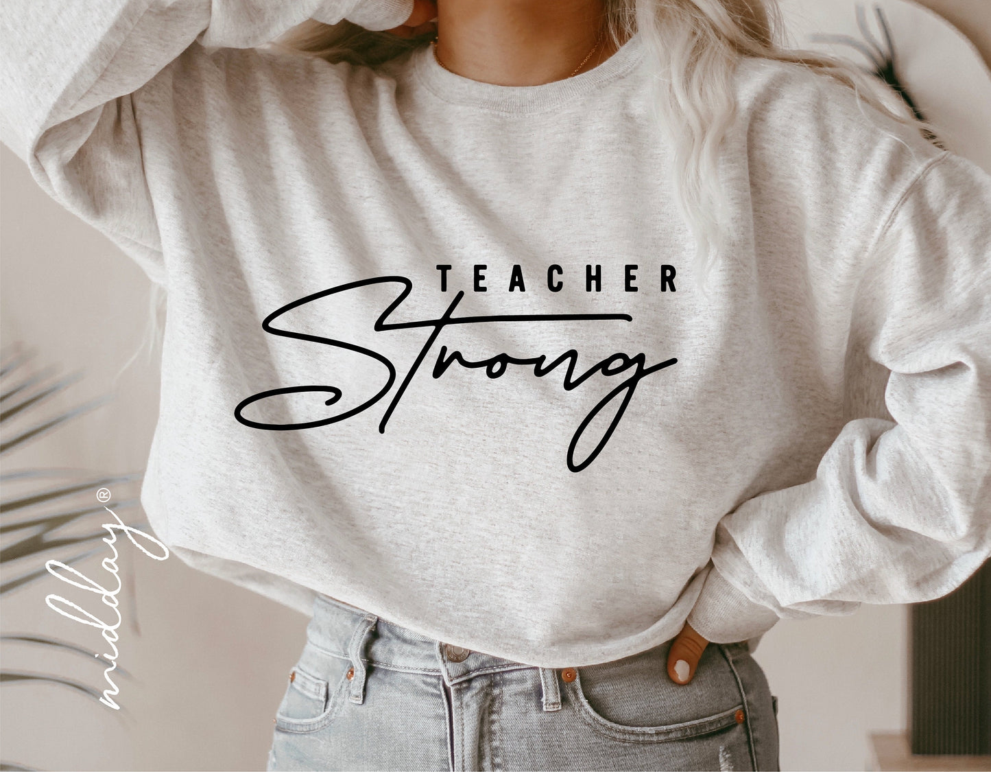 Woman wearing a grey sweatshirt with 'Teacher Strong' text, perfect gift idea for teachers, suitable for Cricut and vinyl cutting projects.