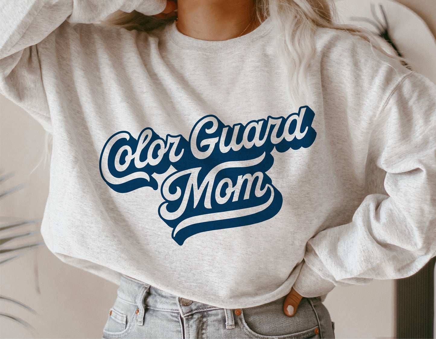 Woman wearing Color Guard Mom sweatshirt with blue lettering, perfect for school spirit and marching band events.