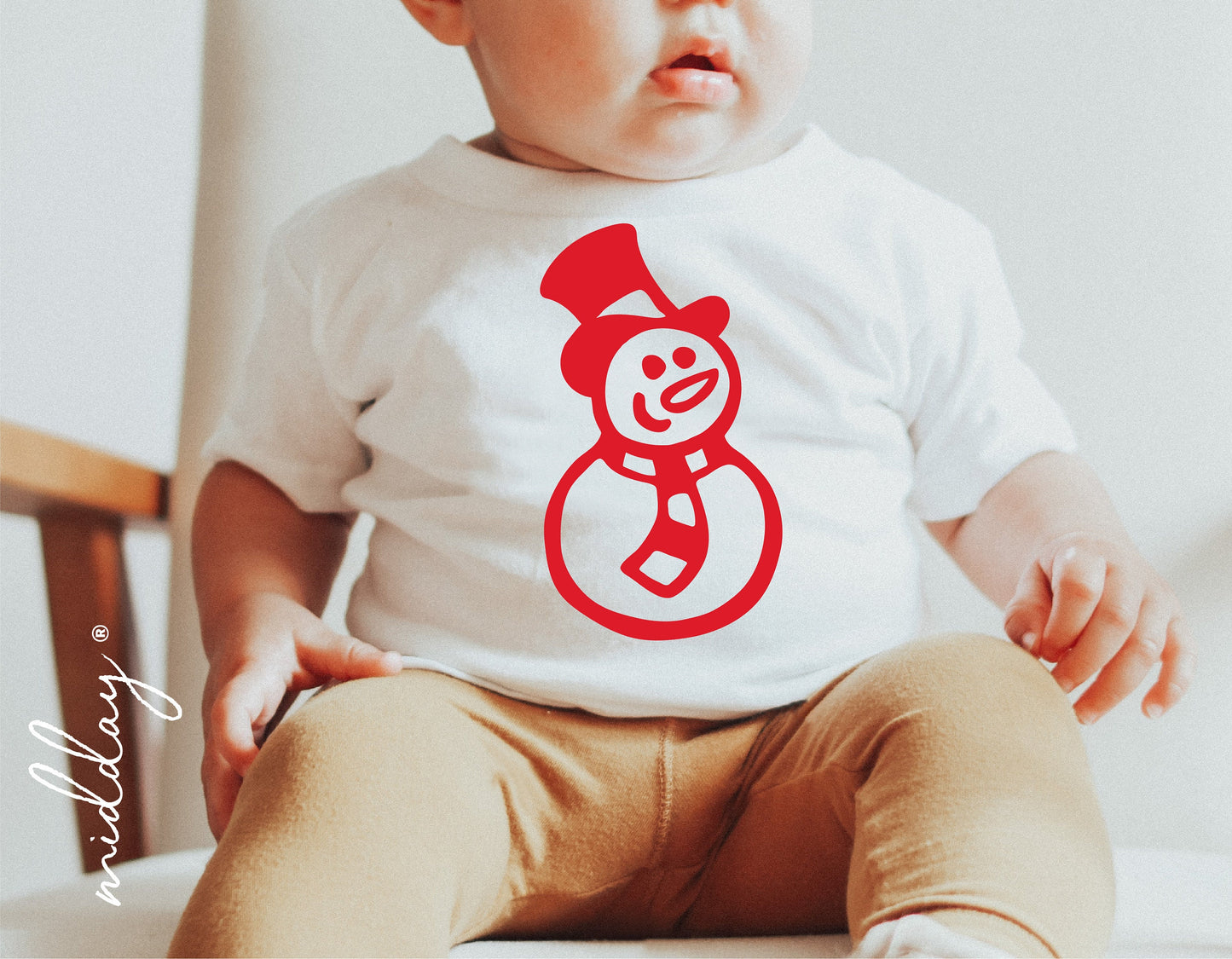 Baby wearing a white shirt with red snowman SVG design, perfect for Cricut and Silhouette holiday projects and decorations.