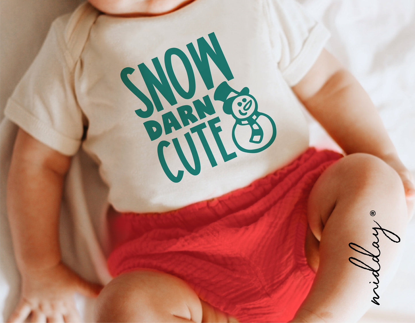Baby wearing a Christmas onesie with 'Snow Darn Cute' snowman design, perfect for holiday Cricut projects and kids' Christmas shirts.
