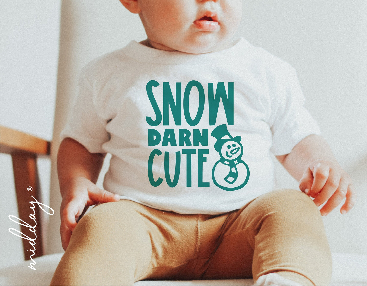 Baby wearing a 'Snow Darn Cute' Christmas shirt with snowman graphic, perfect for holiday decor and Cricut cut files.