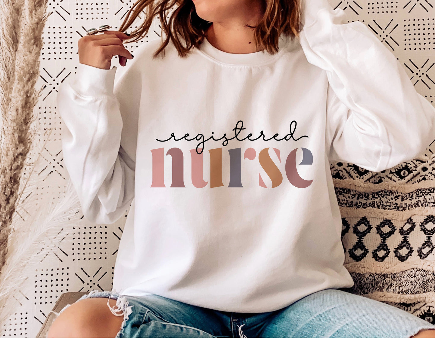 Woman wearing a white sweatshirt with 'registered nurse' design, ideal for nurse appreciation gifts and casual wear.