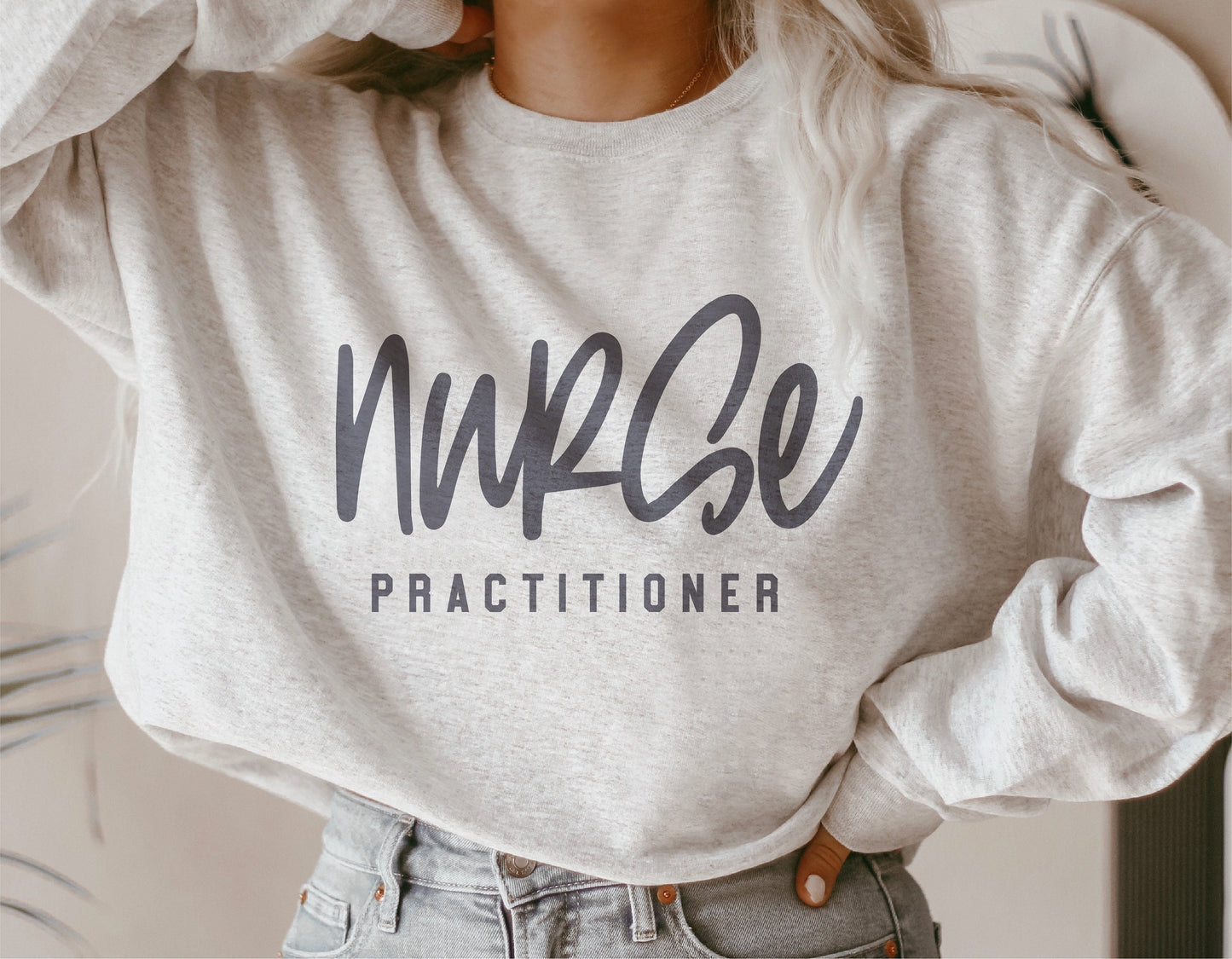Woman wearing a white sweatshirt with 'Nurse Practitioner' text, perfect for nurse appreciation gifts and personalized Cricut projects.