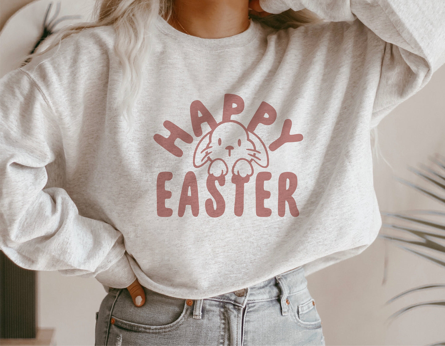 Cozy sweatshirt with "Happy Easter" and bunny face design, perfect for Easter celebrations and casual wear.