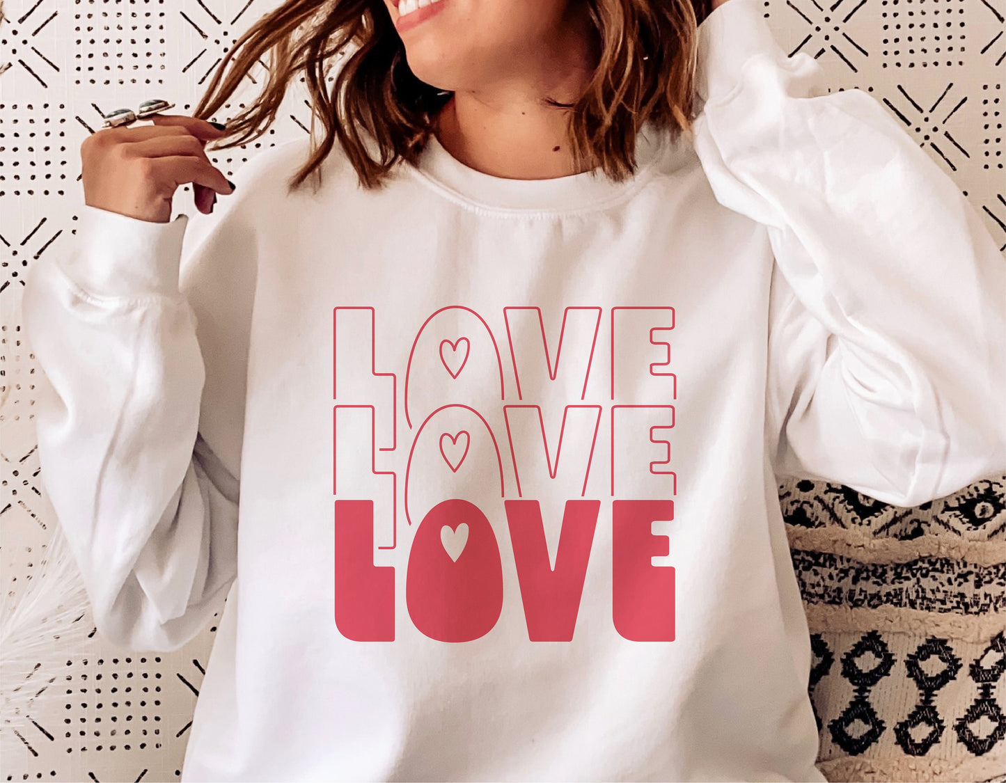 Woman wearing white sweatshirt with "Love Love Love" pink and red Valentine's Day design, ideal for Cricut and Silhouette projects.