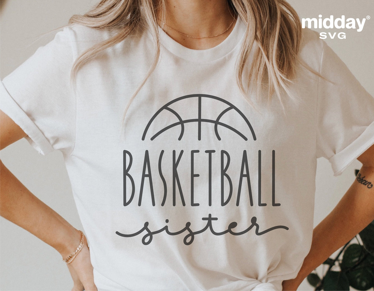 Woman wearing a white t-shirt with 'Basketball Sister' design, featuring a basketball icon, suitable for Cricut and Silhouette cutting.