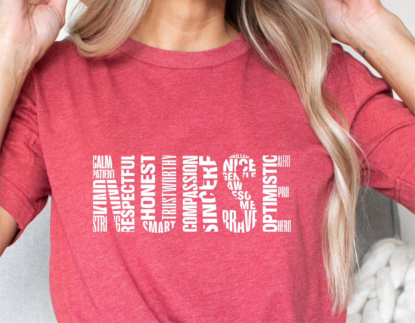 Red nurse shirt with white word art featuring positive attributes of nurses like respect, honesty, compassion, and bravery.