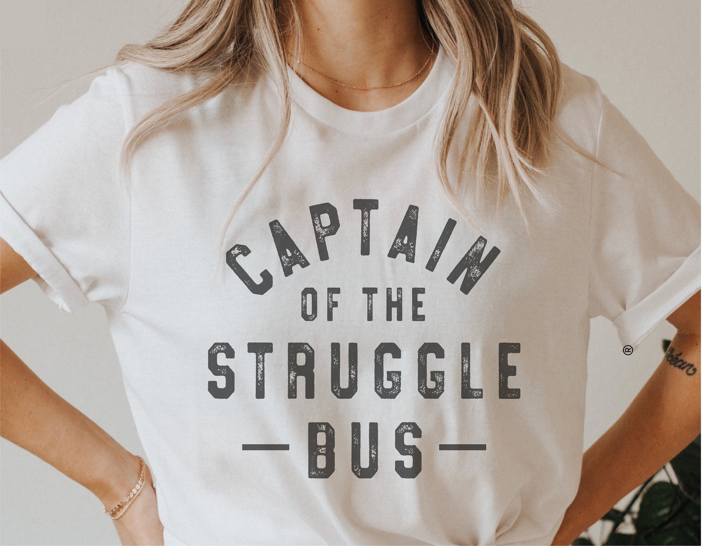 Woman wearing a white t-shirt with 'Captain of the Struggle Bus' text, showcasing a funny SVG design for Cricut and Silhouette projects.