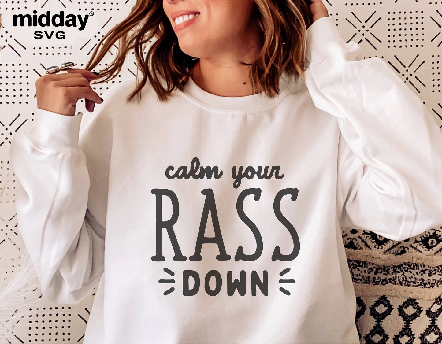 Woman wearing a white sweatshirt with 'Calm Your RASS Down' text design, humorously styled for nurses.
