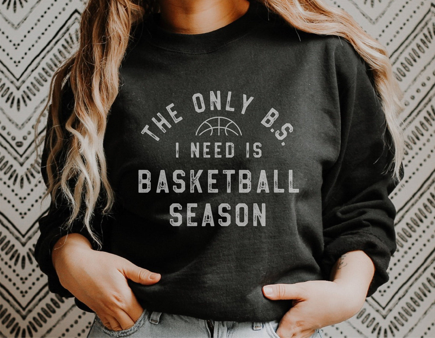 Woman wearing 'The Only B.S. I Need is Basketball Season' black sweatshirt.