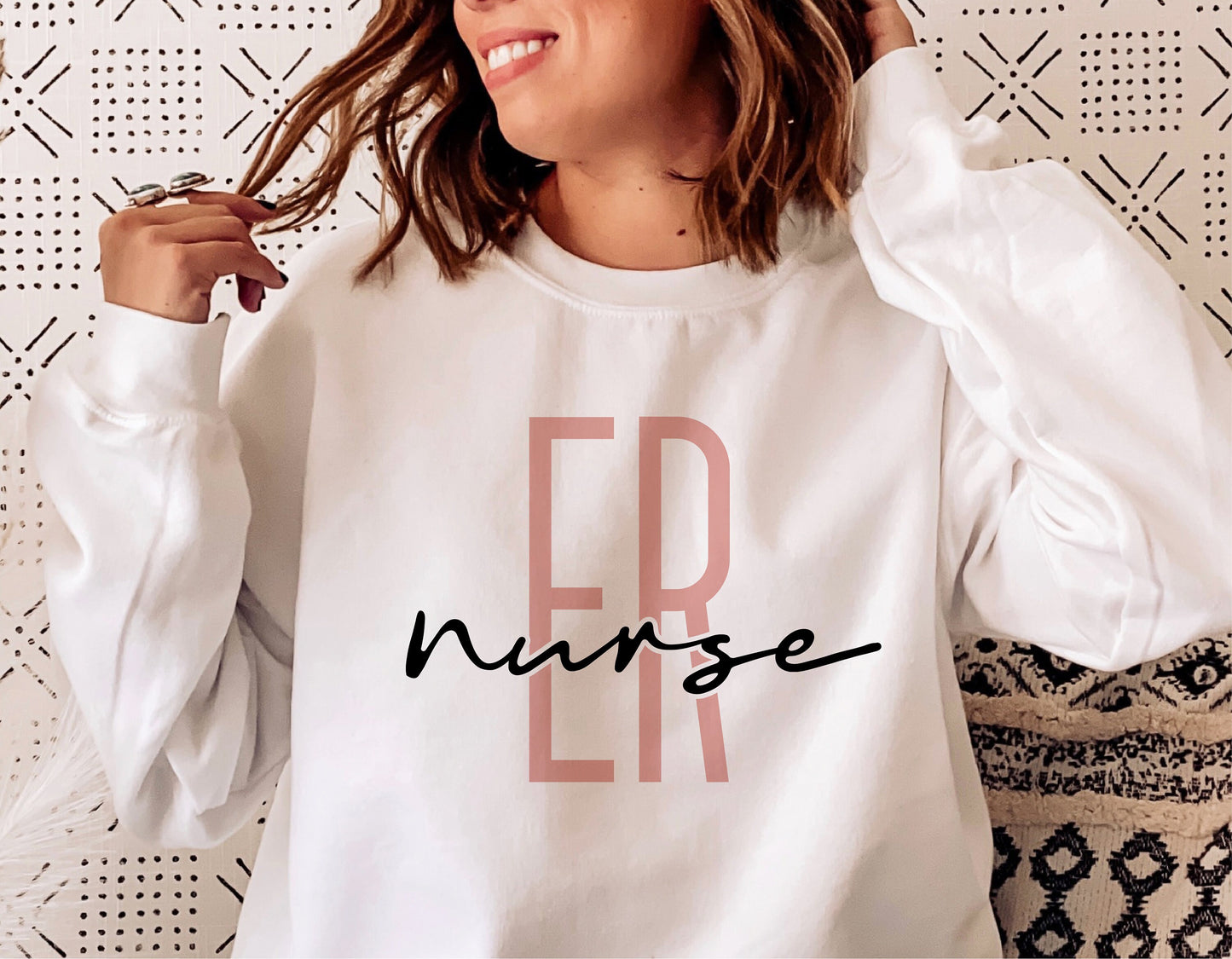 ER nurse sweatshirt with stylish text design worn by a woman.