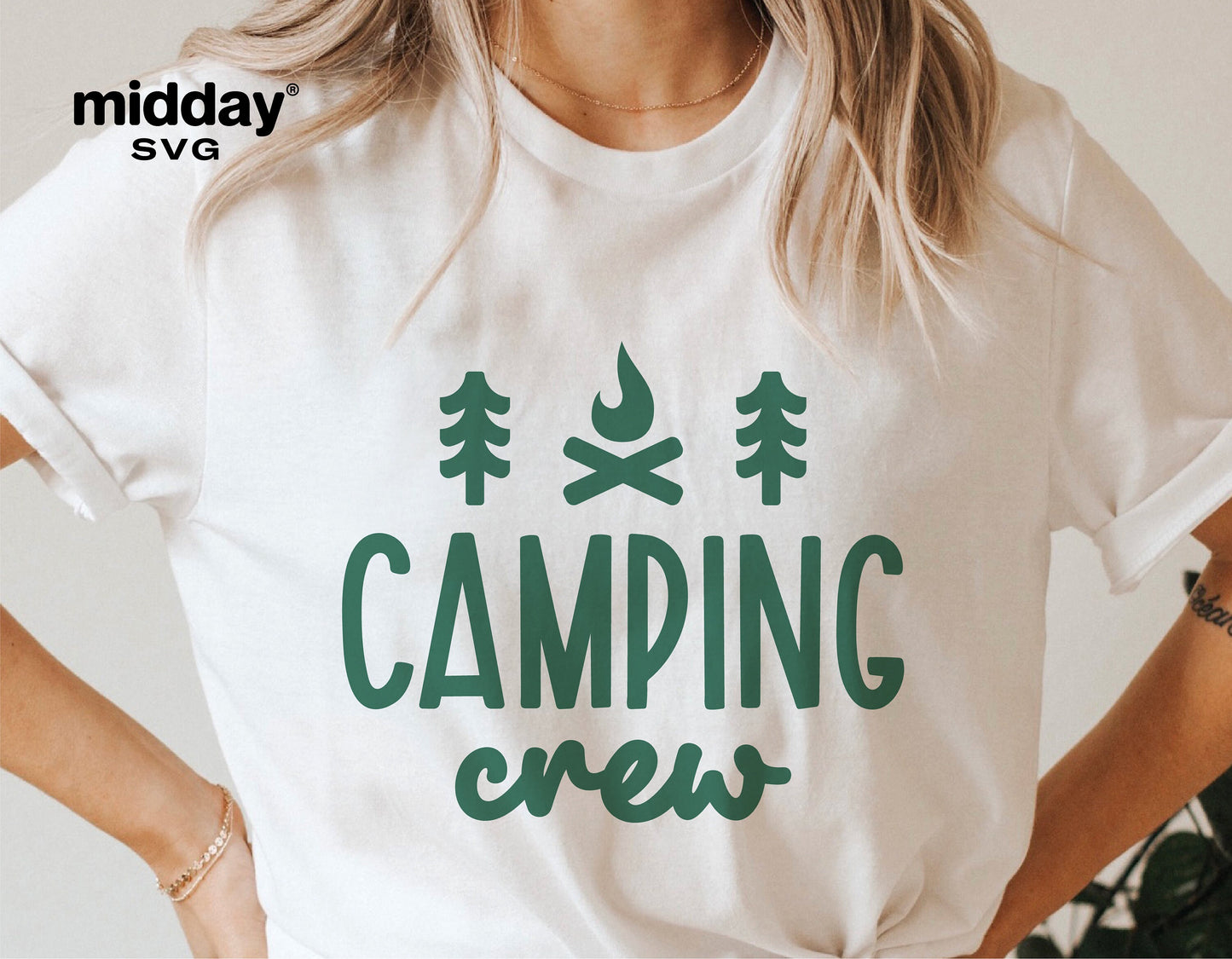 Woman wearing a white t-shirt with green 'Camping Crew' graphic design featuring trees and a campfire, suitable for camping enthusiasts.