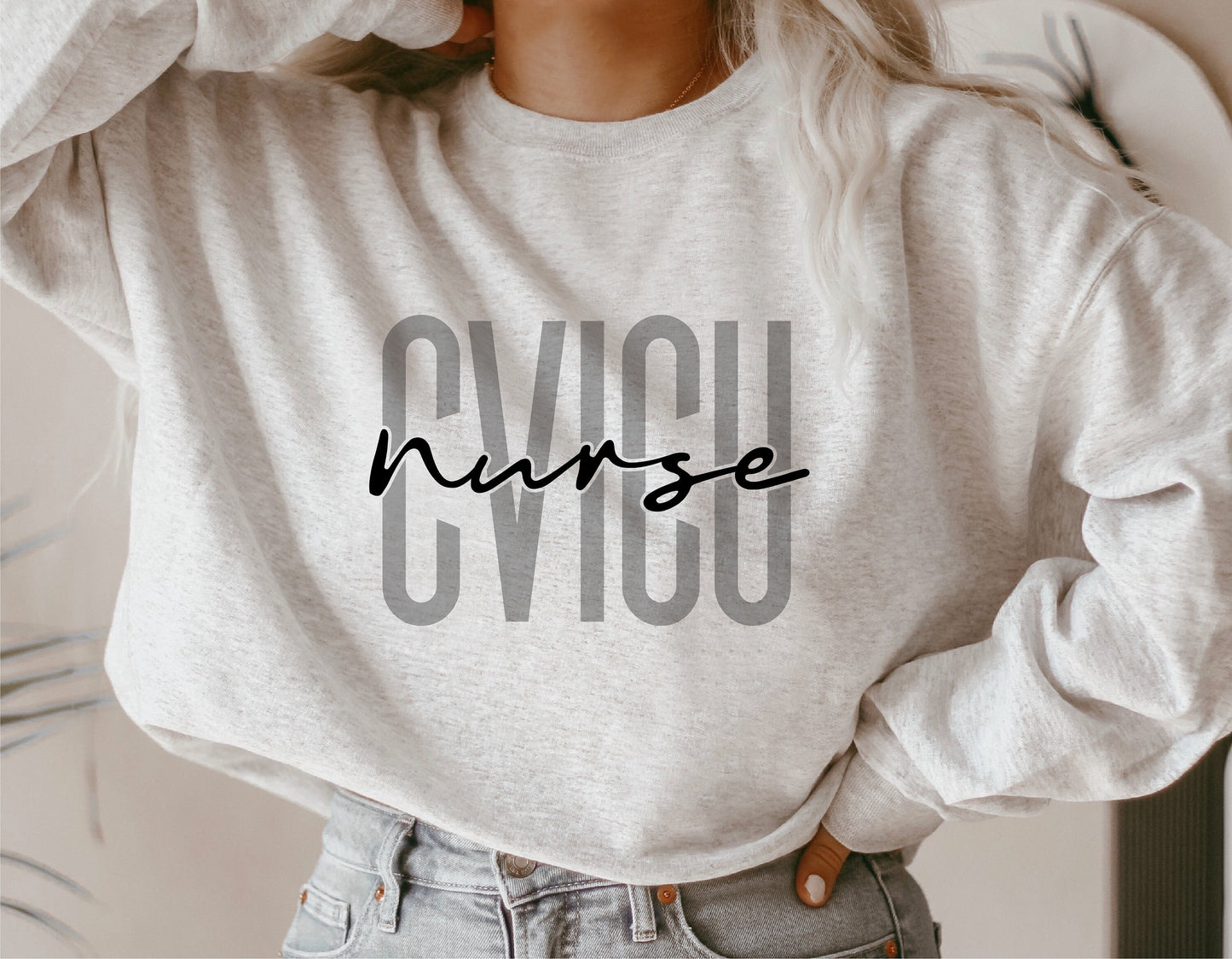 Woman wearing a sweatshirt with 'CVICU Nurse' text, ideal for cardiovascular nurse gifts and nursing students.