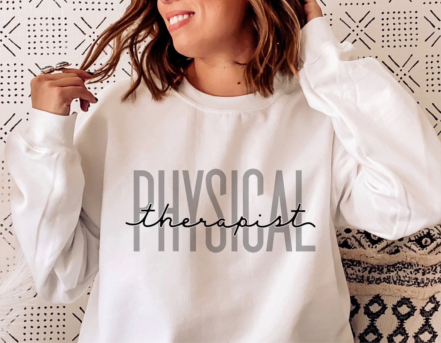 Woman wearing a white sweatshirt with 'Physical Therapist' text, ideal for physical therapy gifts, SVG designs for shirts, mugs, and more.