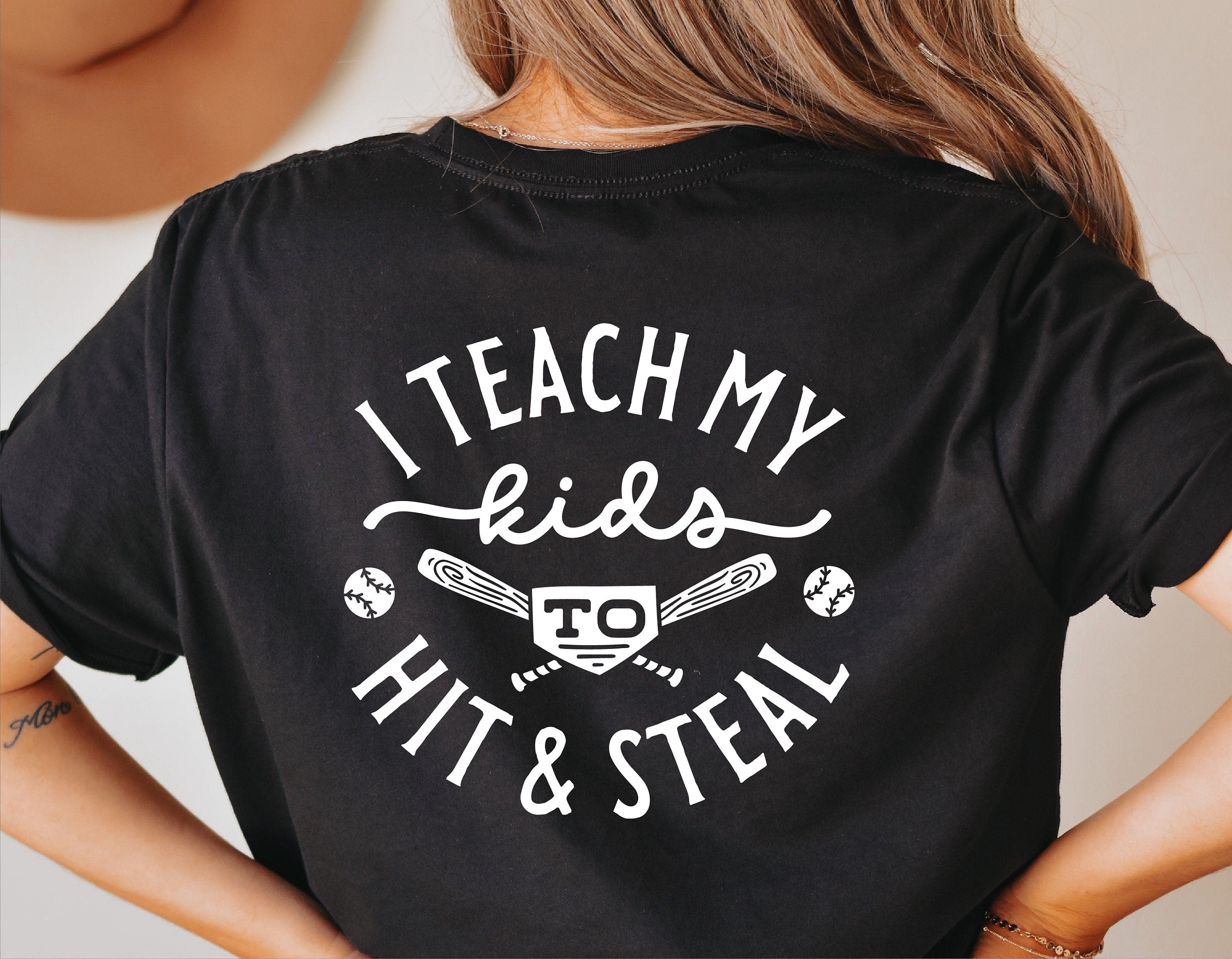 Black shirt with 'I Teach My Kids to Hit & Steal' funny baseball graphic in white text.