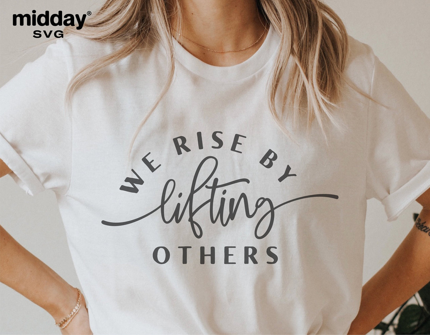 White t-shirt with 'We Rise By Lifting Others' text in stylish font, ideal for Cricut and Silhouette projects, promoting kindness.