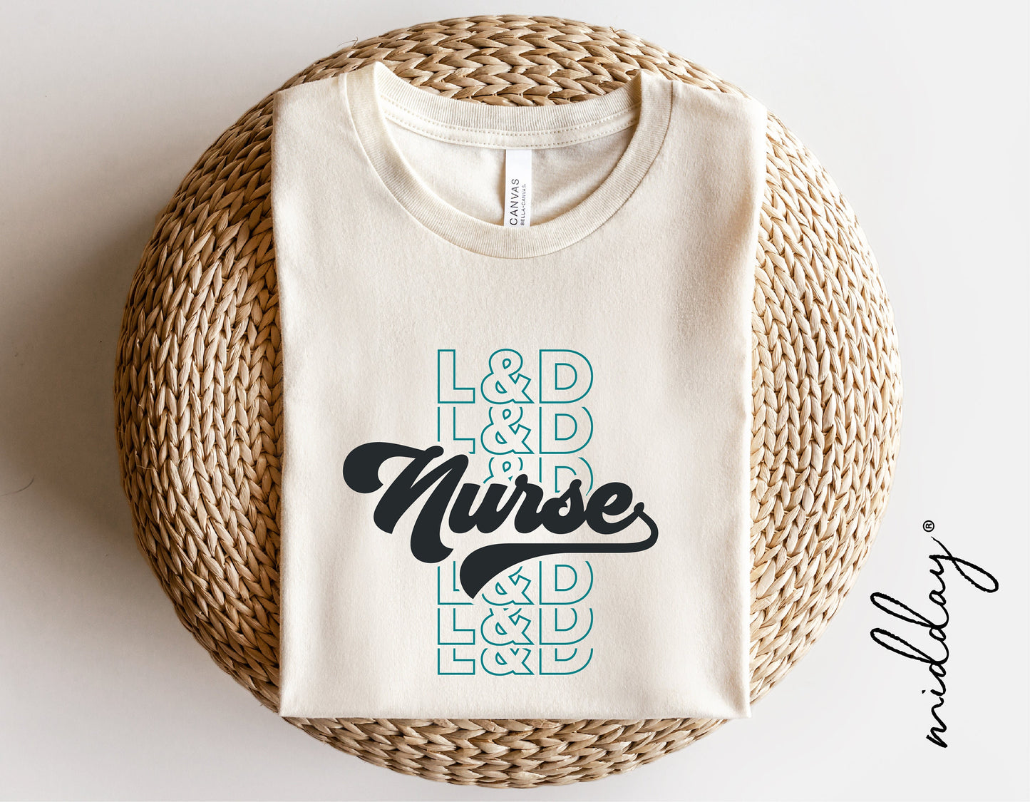Cream L&D Nurse shirt with stylish typography design, featuring text 'L&D Nurse' in black and teal, displayed on woven basket.
