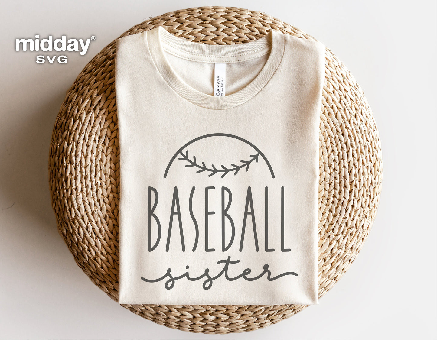 White t-shirt with 'Baseball Sister' print folded on a woven mat, suitable for Cricut and Silhouette projects.