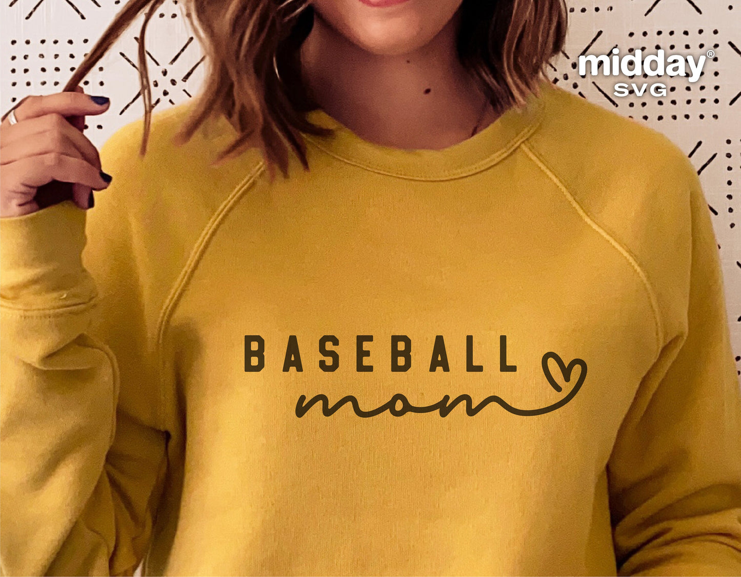 Woman wearing yellow sweatshirt with 'Baseball Mom' text graphic, suitable for Cricut and Silhouette designs.