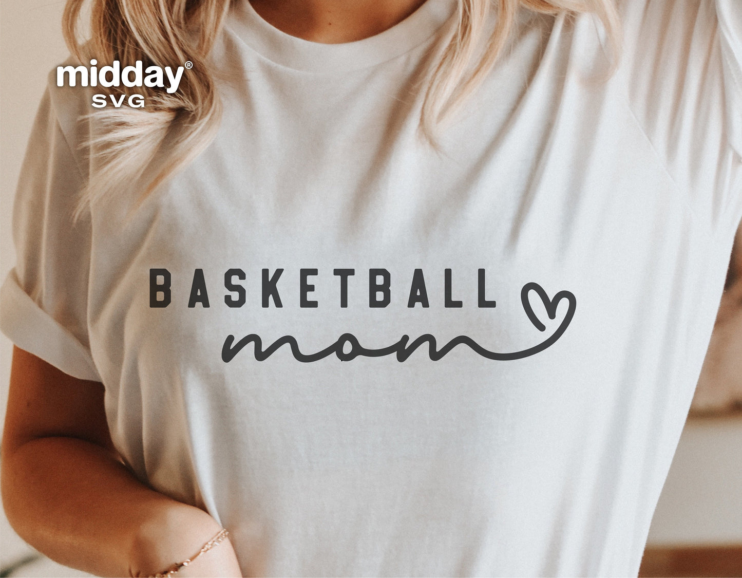 Woman wearing a white t-shirt with 'Basketball Mom' design, ideal for Cricut and Silhouette projects, featuring a heart motif in SVG format.
