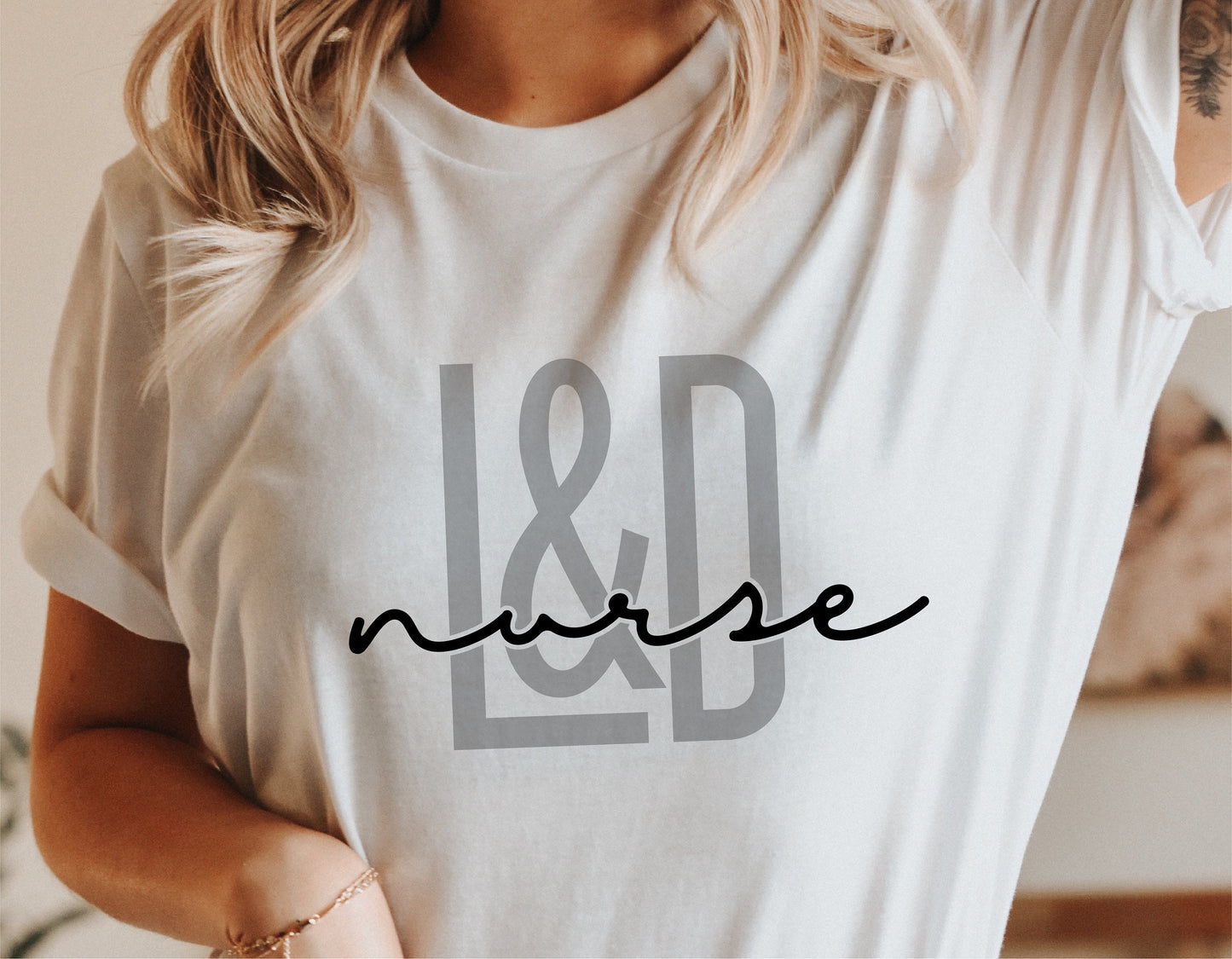 Person wearing a white shirt with stylish 'L&D Nurse' design, perfect for Labor and Delivery nurse appreciation and Cricut projects.