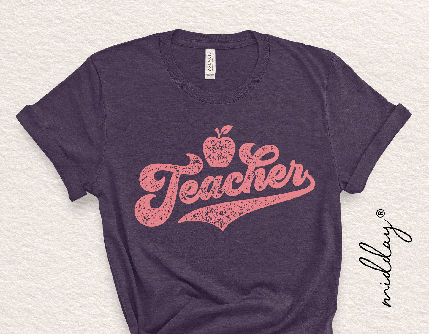 Purple t-shirt with a pink "Teacher" design featuring an apple, ideal for appreciation gifts, shirts, and crafting projects.