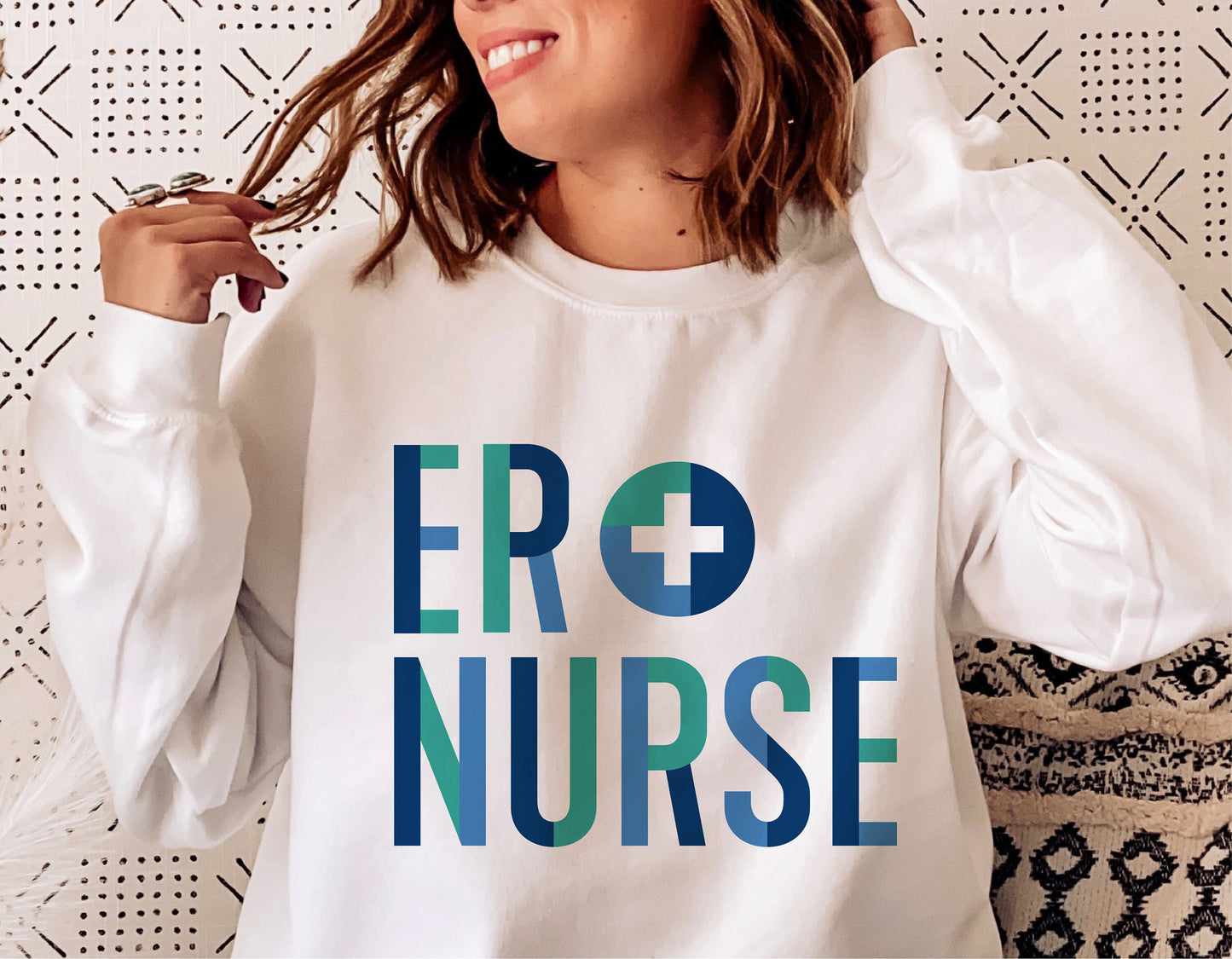 Woman wearing white sweatshirt with 'ER Nurse' design in blue and green, ideal for Cricut and Silhouette projects.