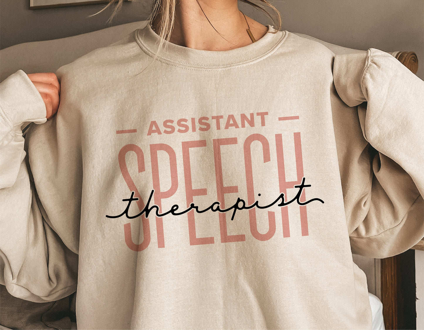 Woman wearing a sweatshirt with 'Assistant Speech Therapist' design, ideal for speech therapy enthusiasts, Cricut and Silhouette projects.