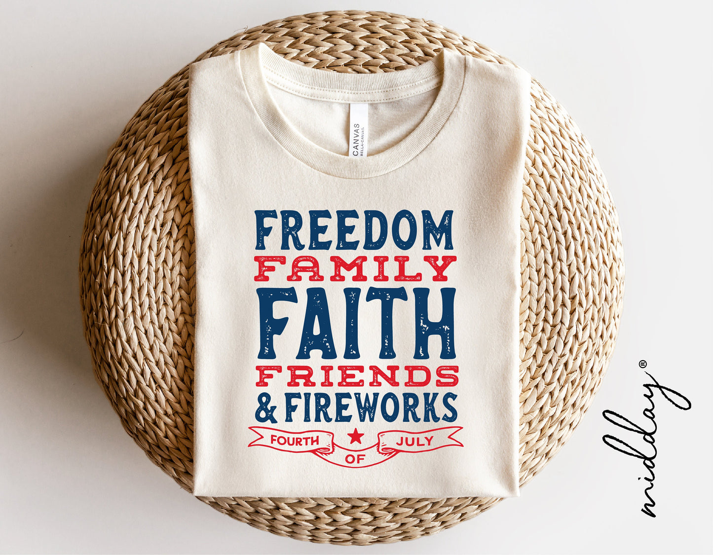 White t-shirt with 'Freedom Family Faith Friends & Fireworks - Fourth of July' printed in blue and red text on wicker background.