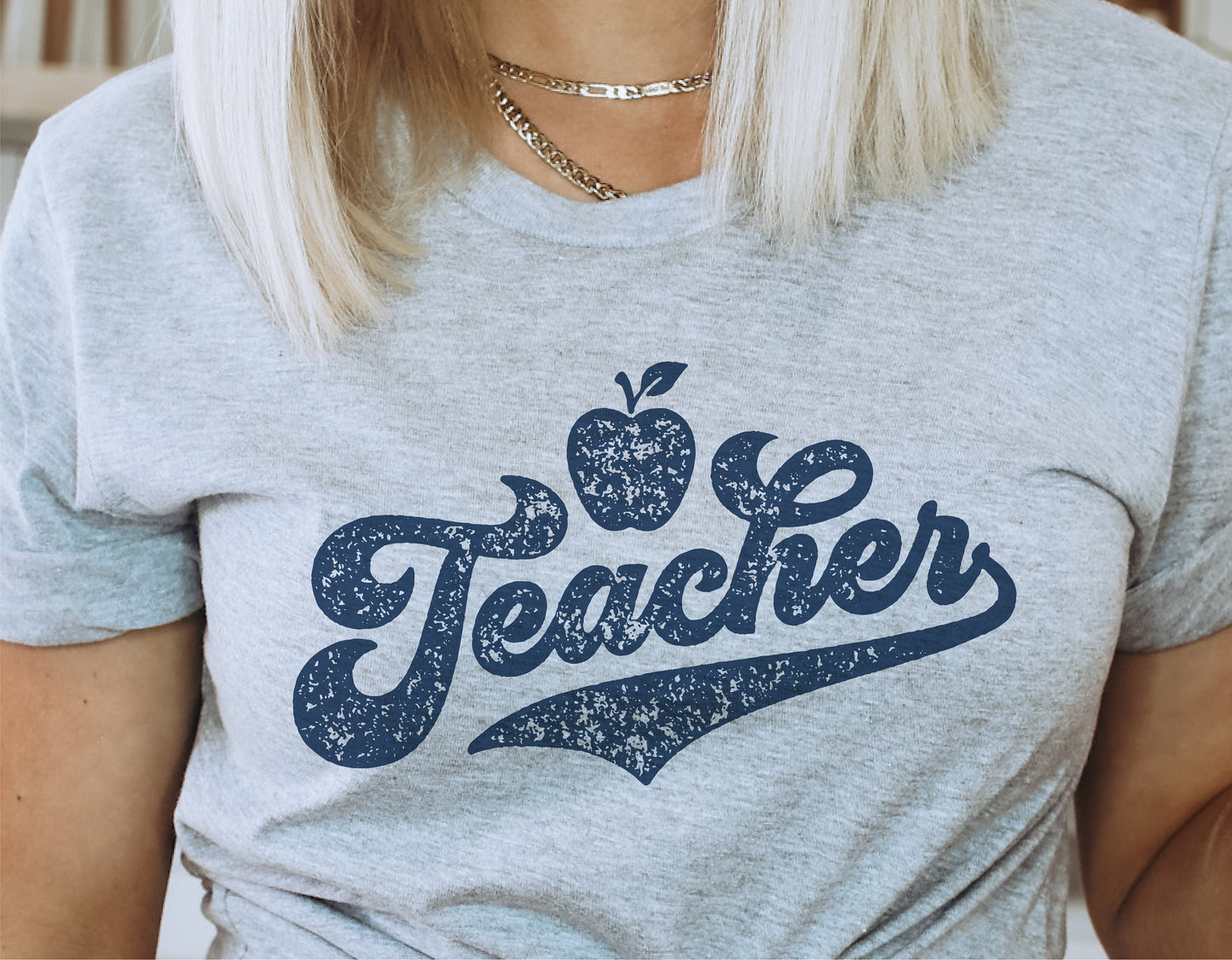 Gray t-shirt with blue 'Teacher' text and apple design, suitable for appreciation gifts and crafting projects using Cricut or Silhouette.