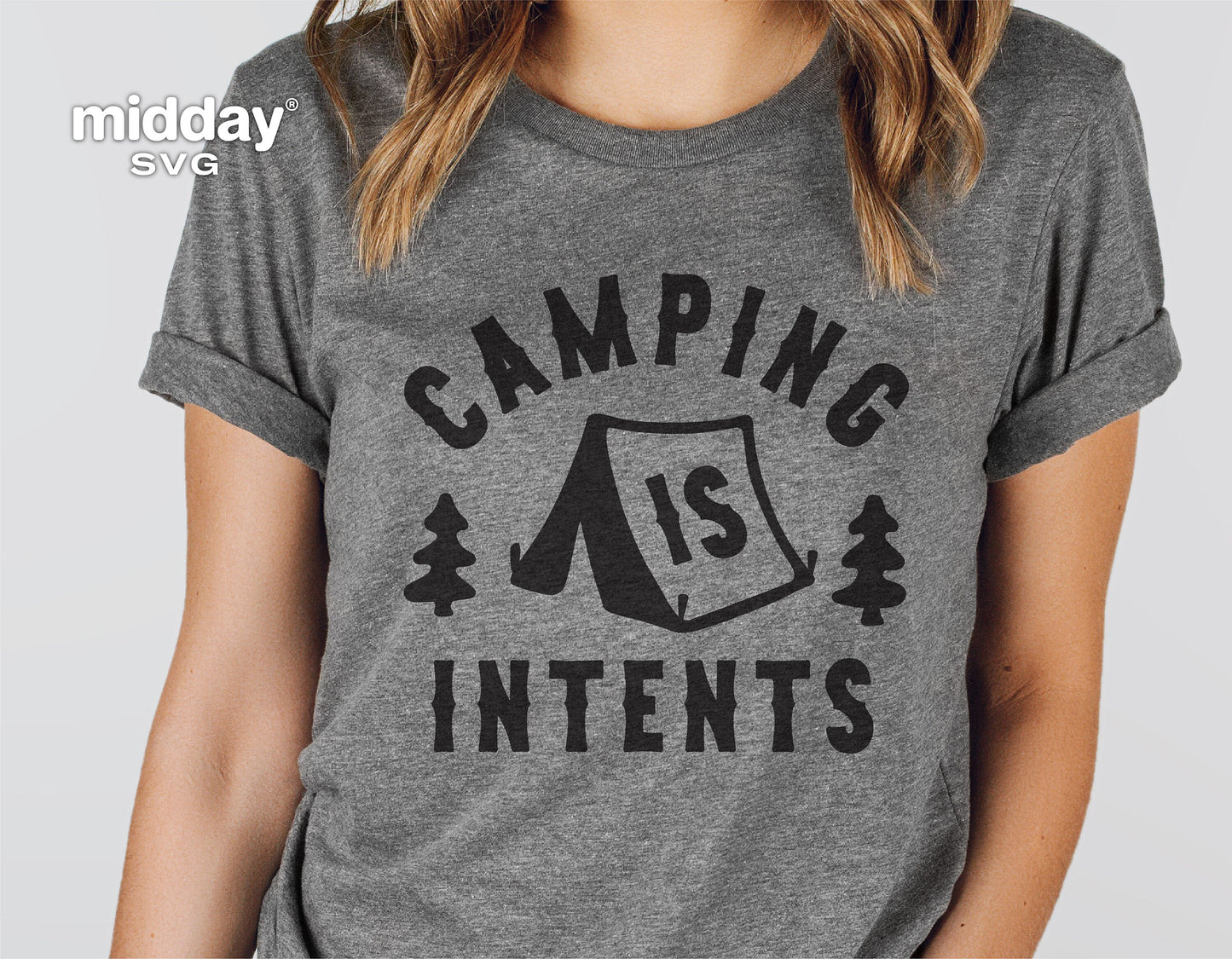 Person wearing a grey t-shirt with 'Camping Is Intents' graphic, showing a tent between two trees, ideal for camping enthusiasts.