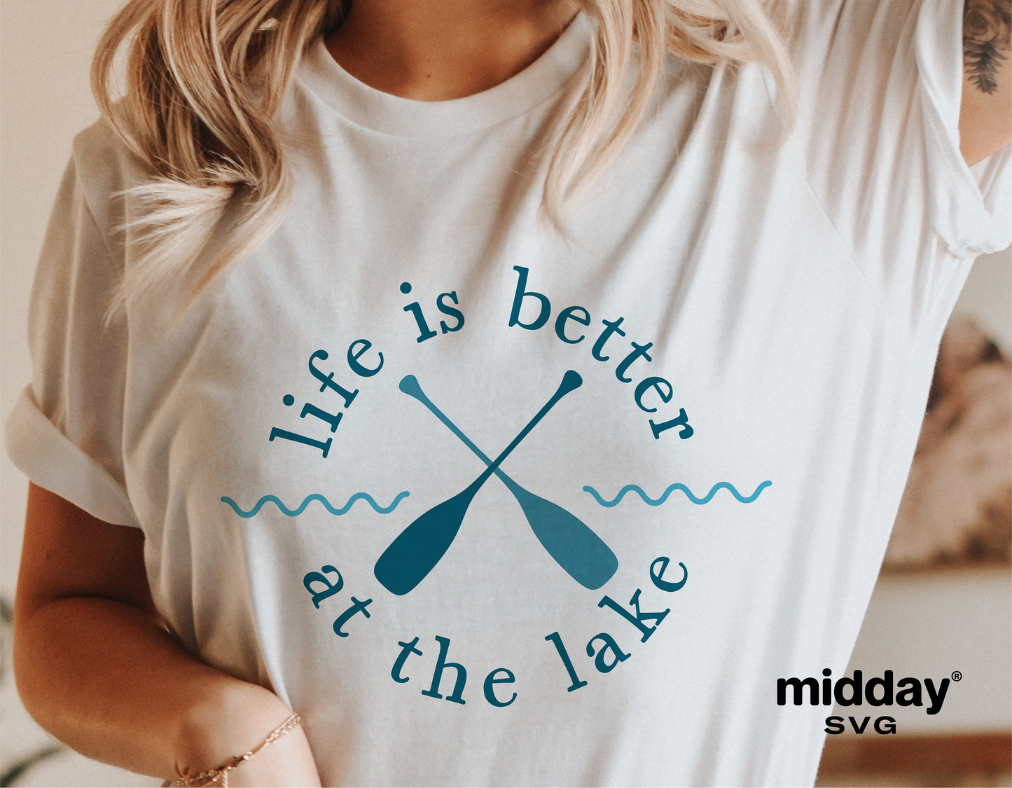 "Life is Better at the Lake" graphic on a white t-shirt, featuring crossed paddles in a relaxed summer lake theme.