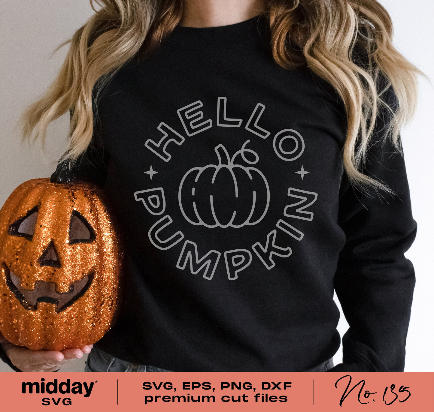 Person wearing a black sweater with 'Hello Pumpkin' design, holding a carved Halloween pumpkin, perfect for fall and Thanksgiving crafting.