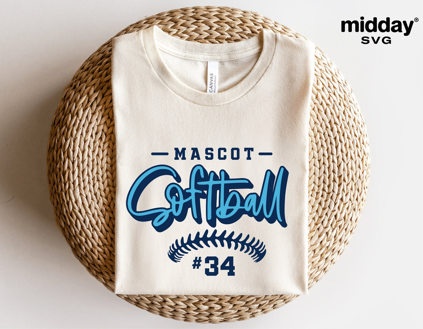 Folded white t-shirt with blue 'Softball' logo design, '#34', on wicker chair, customizable Cricut cut file for DIY projects.