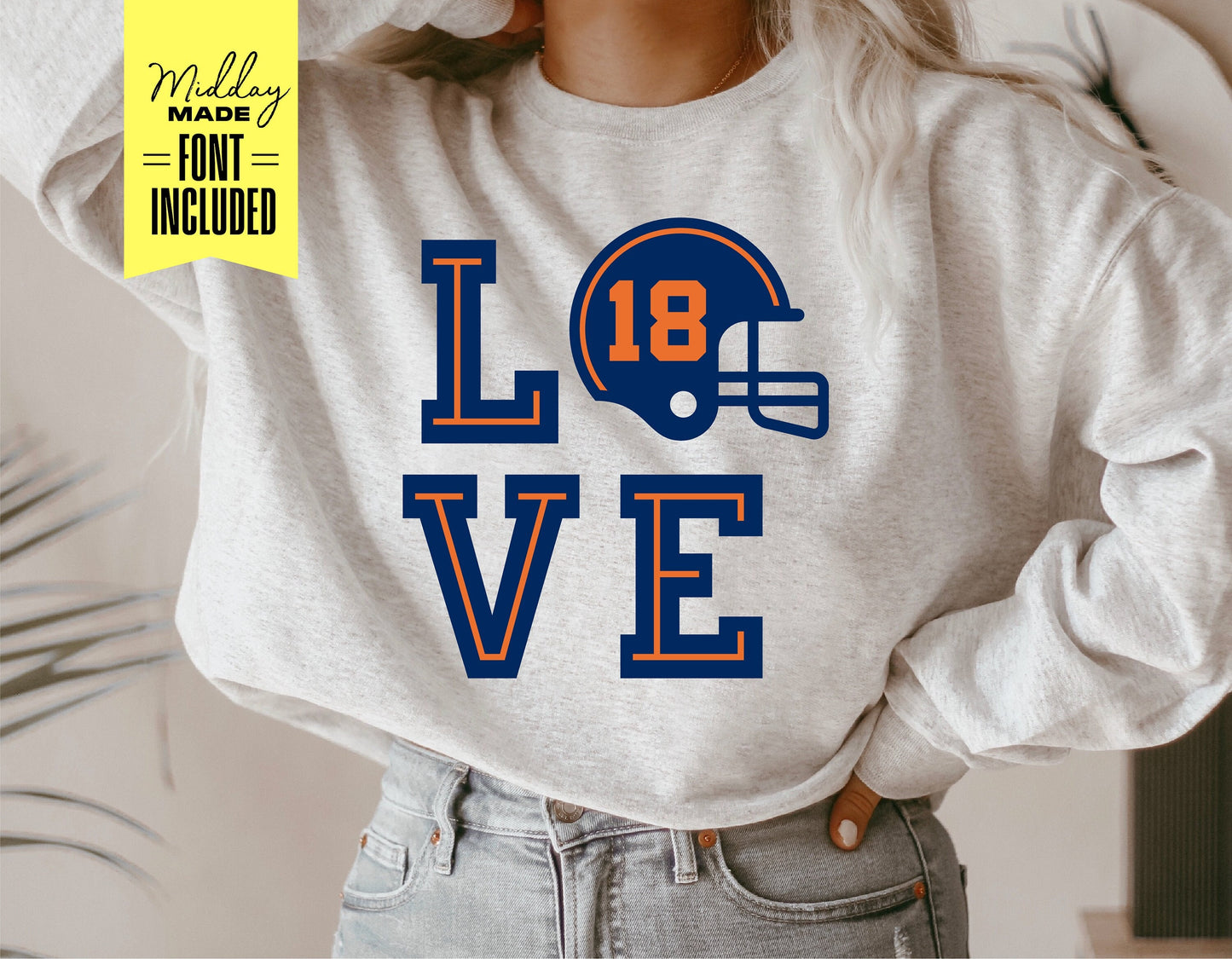 Person wearing a gray sweatshirt with 'LOVE' design featuring a football helmet for Cricut and Silhouette projects.