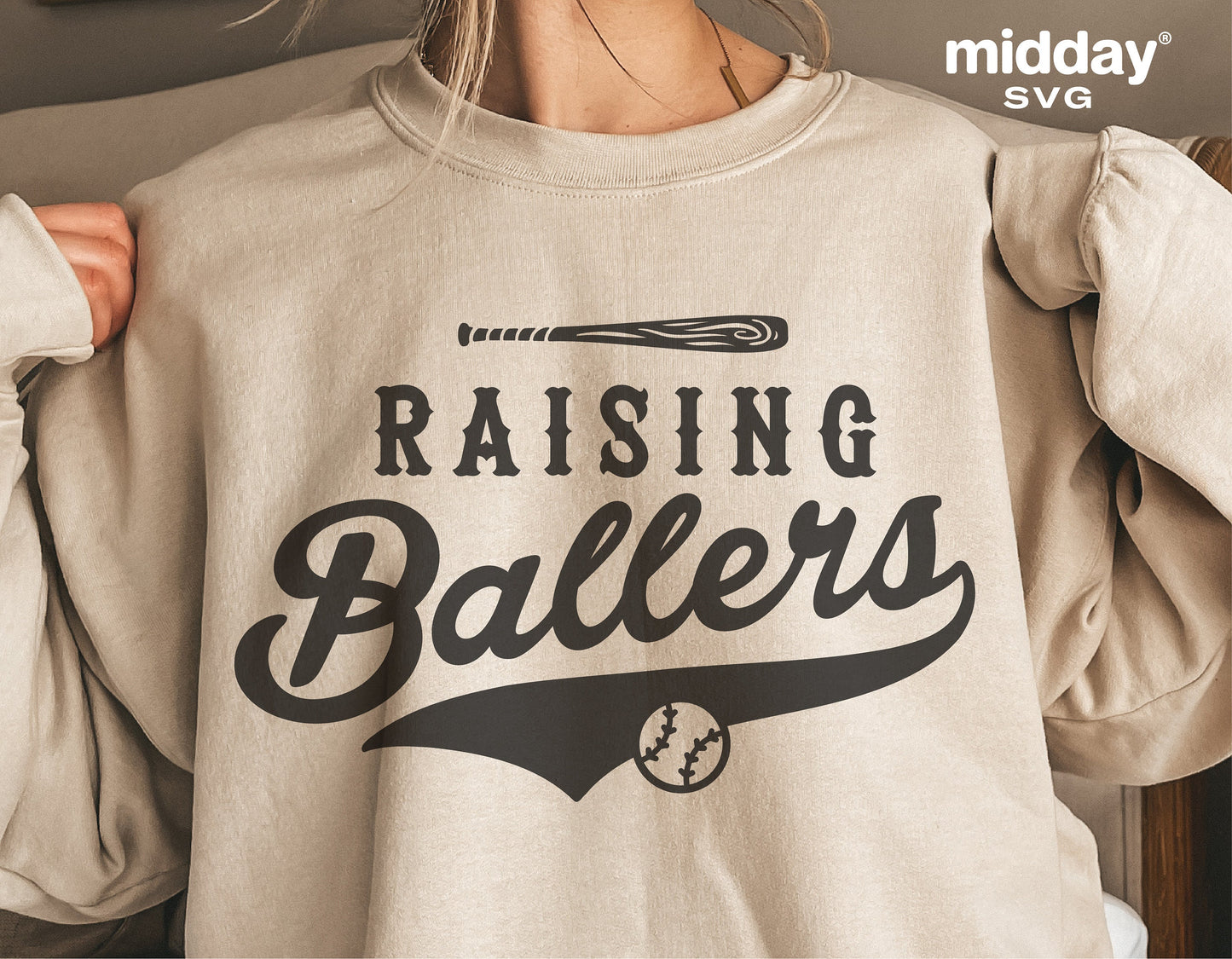 Woman wearing a Raising Ballers sweatshirt with baseball design, suitable for Cricut and Silhouette projects.